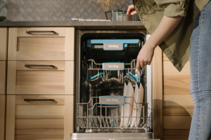 Woman loading her dishwasher with dishes.