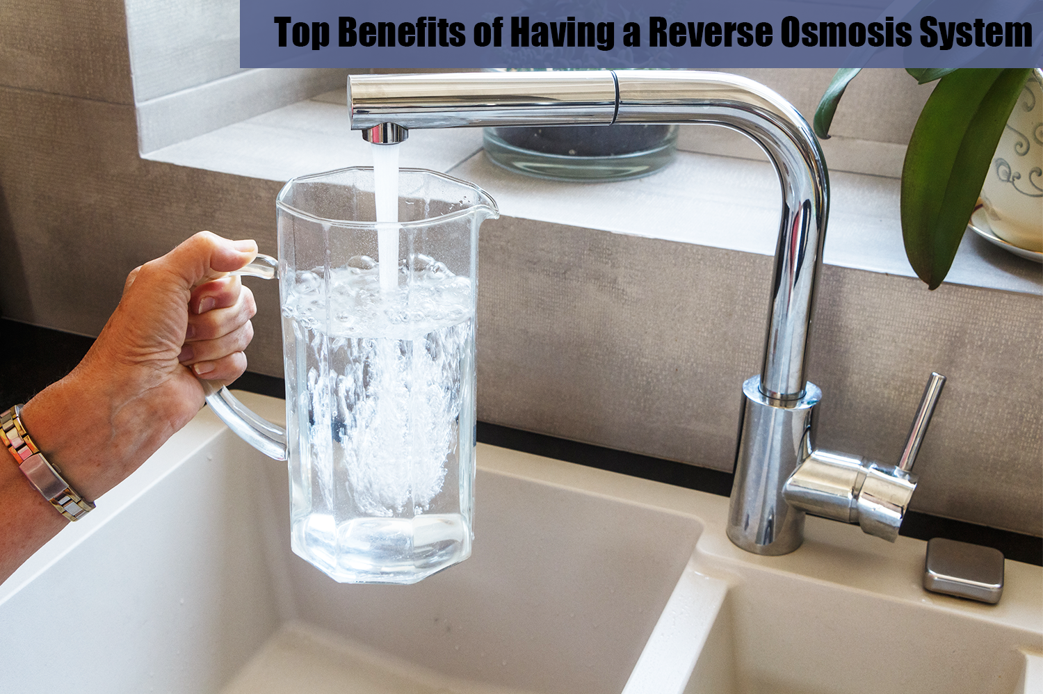 An anonymous person filling up a glass water pitcher with tap water provided by a reverse osmosis system.