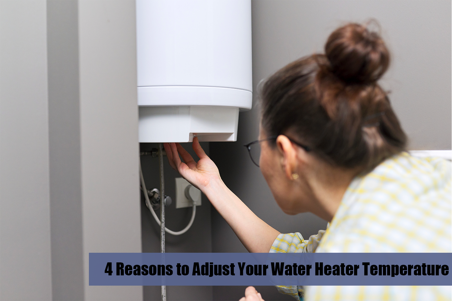 A woman with brown hair turning down the temperature on her water heater.