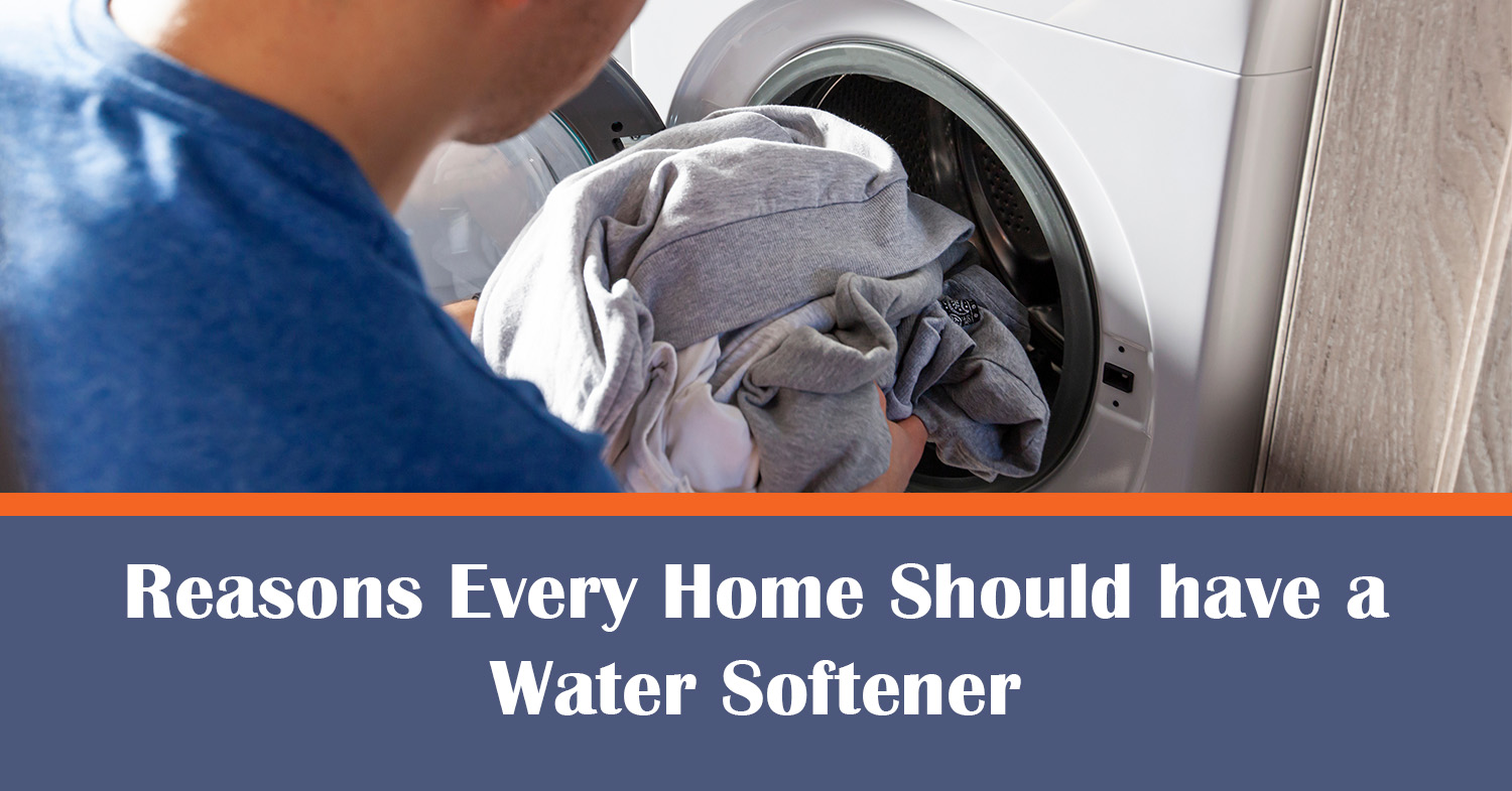 A man taking clothes out of his washing machine using a water softener.