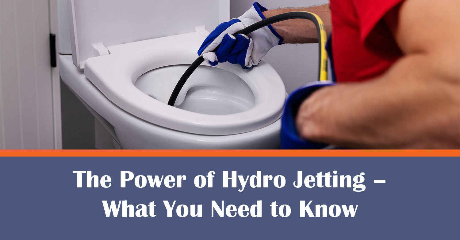 A plumber unclogging a toilet with hydro jetting.